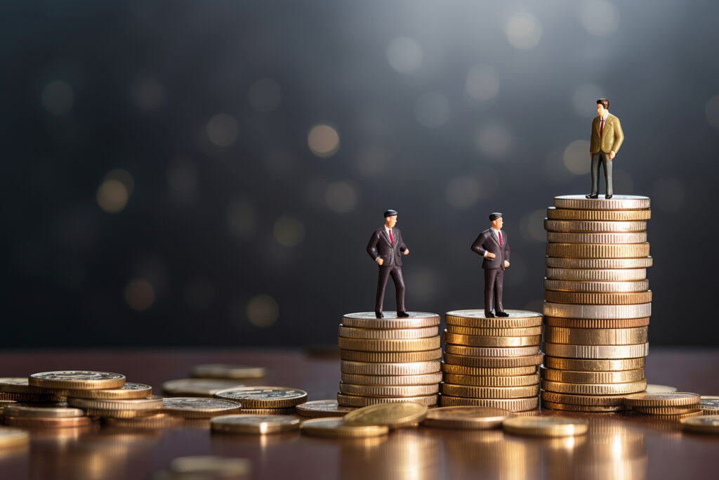 Miniature businessmen standing on stacks of coins representing growth from banking to wealth management