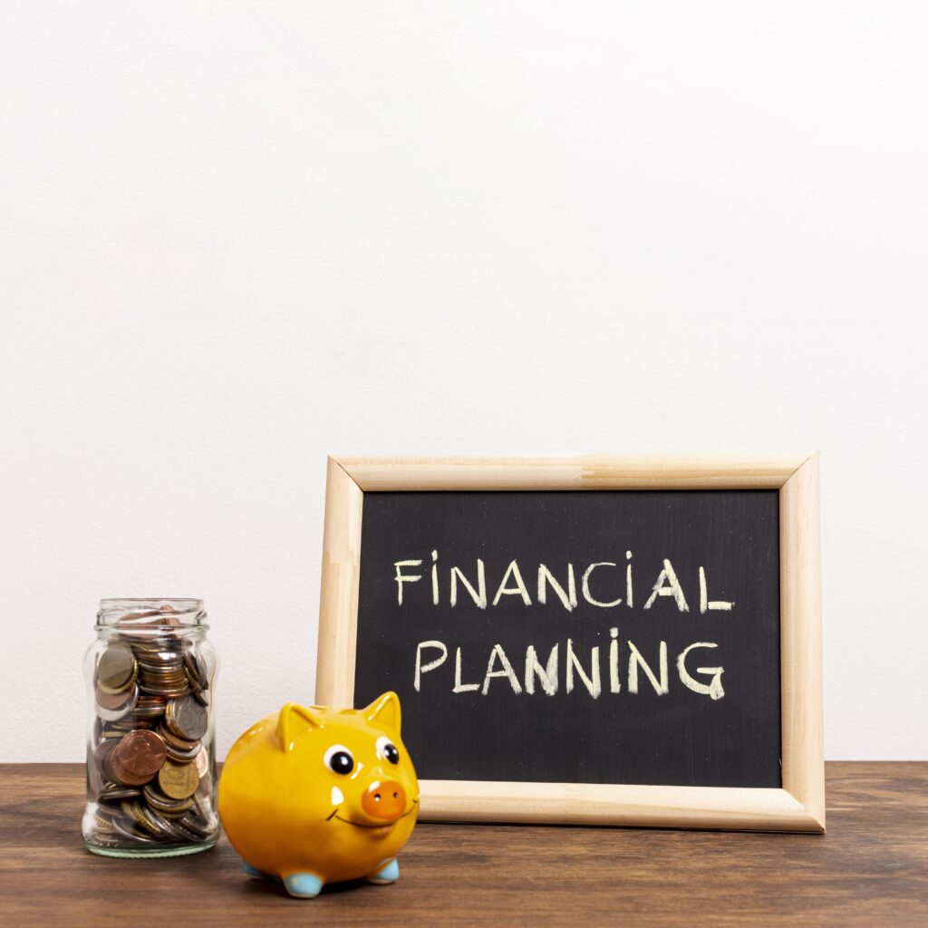 A jar of coins and a yellow piggy bank beside a chalkboard with the words Financial Planning