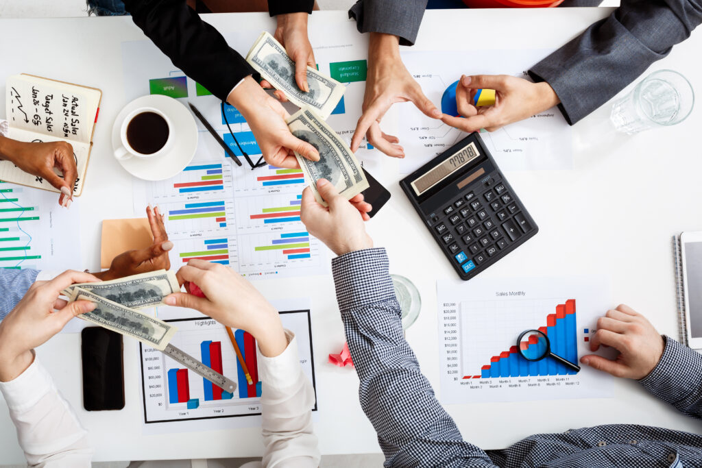 Businessmen hands reviewing financial documents and drafts on a white table
